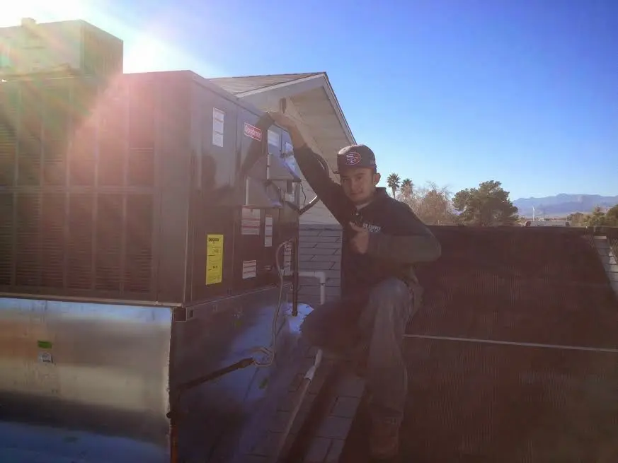 HVAC technician performing HVAC Inspection on a rooftop unit in Uhrichsville